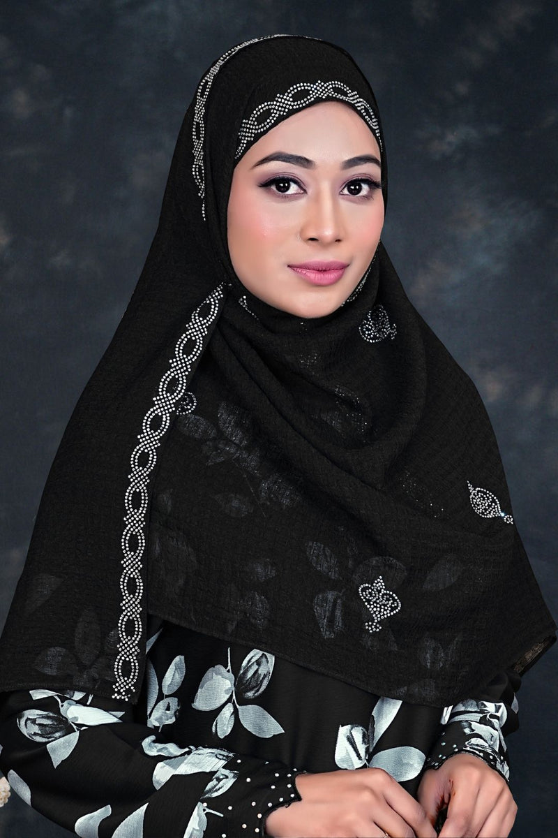 Woman wearing a black hijab with intricate patterns